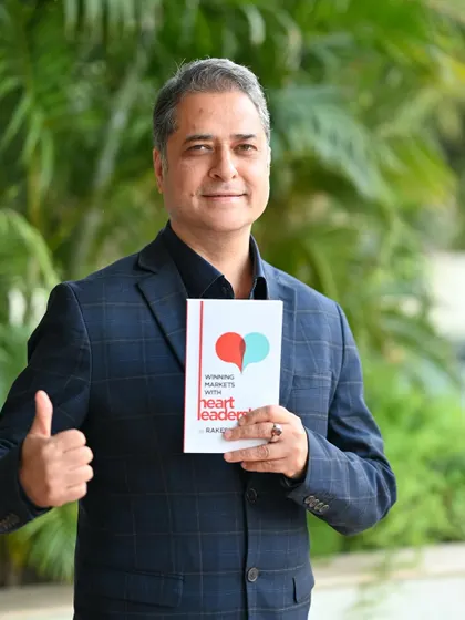 An outdoor portrait of the author giving a thumbs-up with his book. This creates a positive and successful image, great for social media announcements.