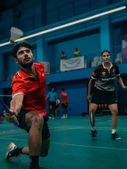 A powerful lunge to the net. This action shot captures the athleticism and precision required for effective net play in a doubles match.