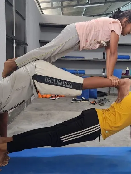 A three-person plank stack using the wall for the base, a creative and challenging group exercise.