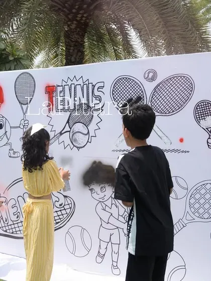 Kids enjoying the graffiti wall activity, a unique and engaging element that makes the party memorable.