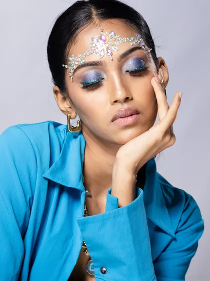 An elegant pose from the same shoot, with the model's hand gently touching her face.