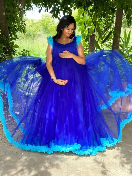 A peaceful moment captured, with the mother-to-be cradling her bump in the gorgeous blue trail gown.