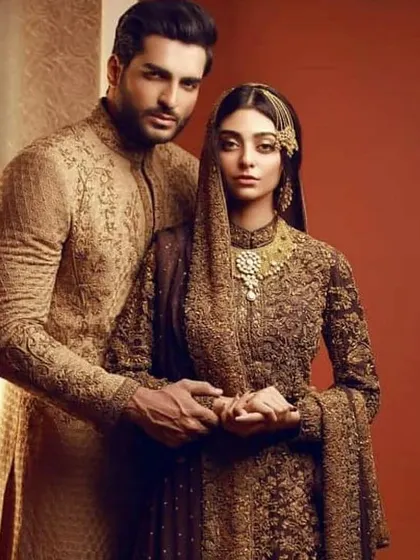 A truly royal pairing. The deep, rich embroidery on both the bride's and groom's outfits creates a sense of shared opulence and tradition.