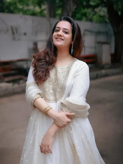 A happy, candid shot of Spruha Varad, looking radiant in the elegant white ensemble.