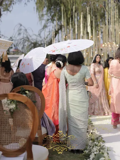 Guests using the elegant white umbrellas, which add to the overall aesthetic of the event.