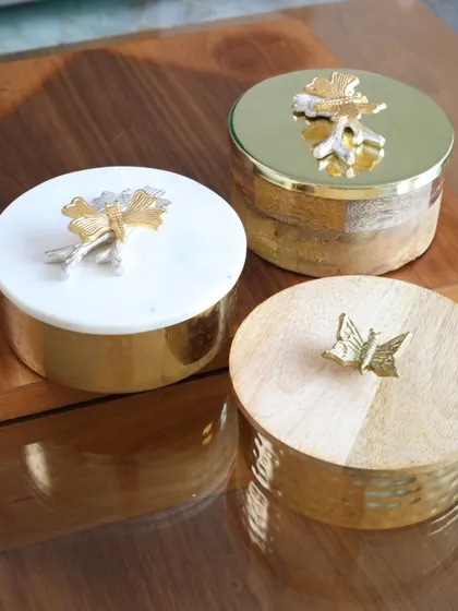 A trio of our exquisite keepsake boxes, showcasing the different designs available. From marble and wood to hammered metal, each box is a unique piece designed to hold your most precious items.