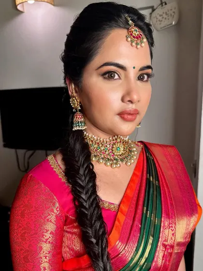 A beautiful look with a fishtail braid. The makeup is kept soft and glowing, with a warm lip color that complements her multi-toned silk saree.
