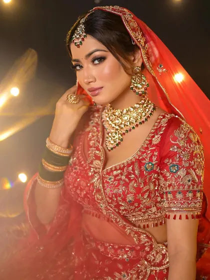 A powerful and confident pose. The makeup is bold and defined, creating a look that is both modern and deeply rooted in tradition.