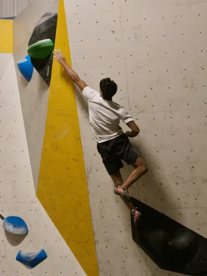 This climber makes a long reach on a complex route, demonstrating the kind of skills we build during our training sessions.