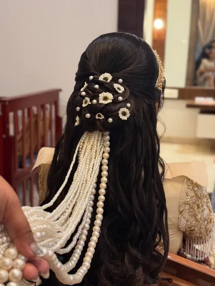 A close-up shot showing the combination of pearls and flowers in this elegant reception hairstyle.