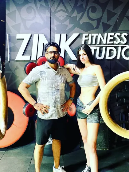 A photo with a client in front of our gymnastic rings. These are a great tool for advanced bodyweight training, and it's always rewarding to see clients progress.