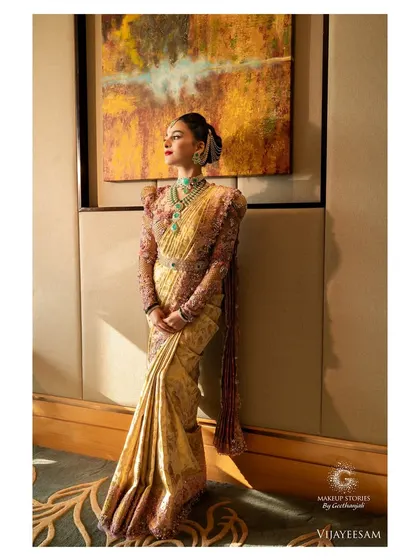 A full-length shot capturing the grandeur of Krishna's bridal attire. The makeup stands out, yet harmonizes perfectly with the heavily embroidered blouse and rich silk saree.