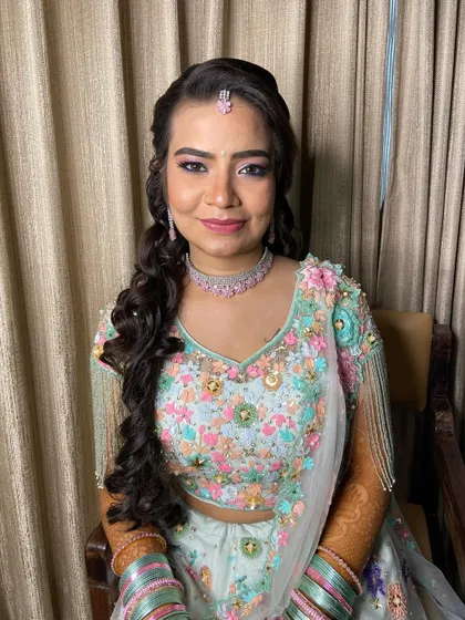 The bride looking directly at the camera, showcasing her beautiful smile and the fresh, floral-inspired makeup.