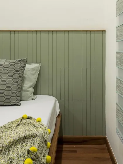 A detail shot of the minimalist bedroom, showing the clean lines of the wall paneling and the clever, concealed bedside niche before it's opened.