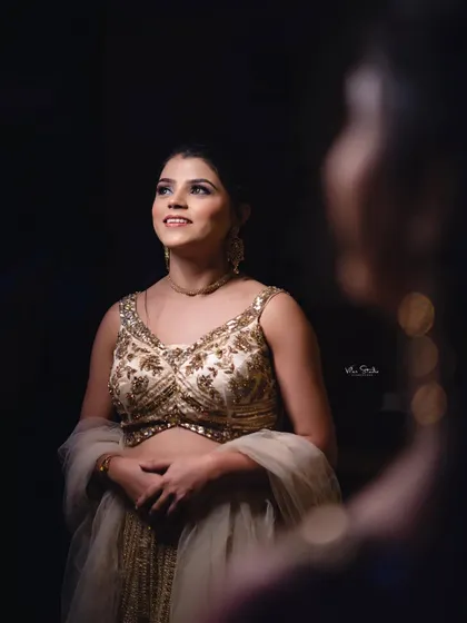 A creative portrait using a reflection. The bride-to-be looks up towards the light, while her reflection is captured in the foreground, adding depth and artistry to the shot.
