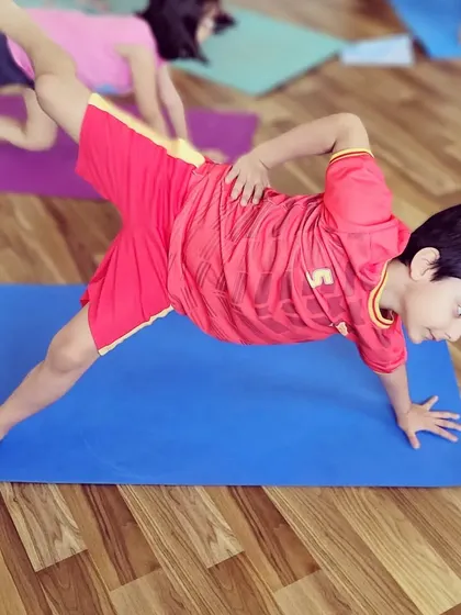 A young student works on his core and balance with this side plank variation. Building strength at a young age is so beneficial.