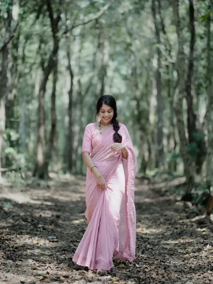 A full-length shot of the same scene, showing the model walking through a beautiful, tranquil forest path.