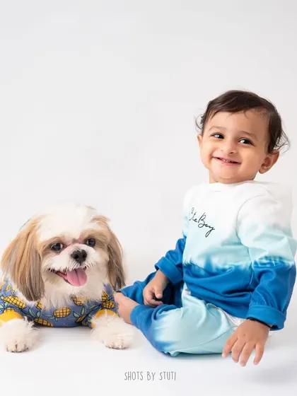 Two adorable munchkins in the studio. This photo perfectly captures the sweet and playful friendship between a baby and his dog.