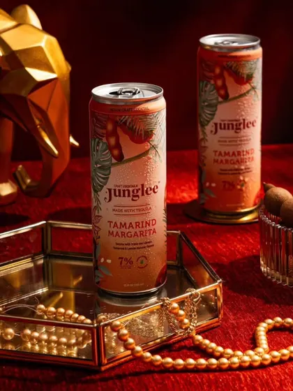 A rich, warm-toned shot for Junglee's Tamarind Margarita. The red background and gold accessories create a feeling of opulence and evening indulgence.