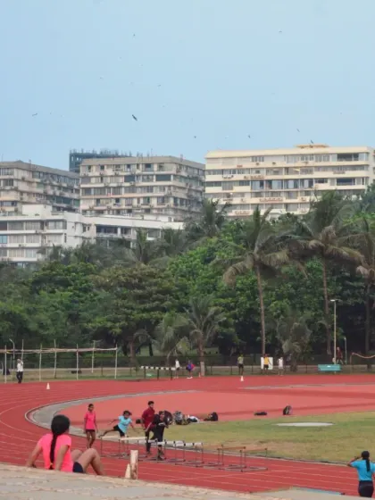 A view of the athletics track on a clear day, with athletes training in the distance. This is the perfect place to start your week with a positive and energetic mindset.