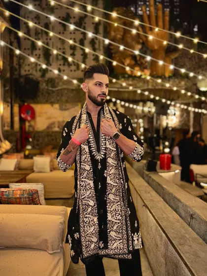 This look is perfect for a festive night out. The black embroidered kurta is elegantly draped with a matching shawl, creating a layered and sophisticated silhouette for any celebration.