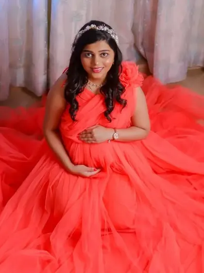 Our coral net gown is incredibly versatile. These studio shots show how it can be styled for elegant, seated portraits, with the fabric creating a soft pool of color.