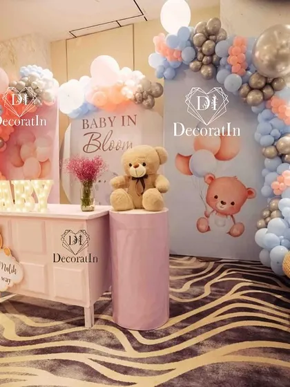 A dreamy "Baby in Bloom" baby shower setup. This beautiful arrangement uses soft pink, blue, and silver balloons, adorable teddy bear props, and custom backdrops to create a sweet and elegant celebration.