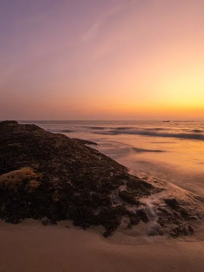 A minimalist long exposure of a rock on a sandy beach at sunset. The image is about the simple beauty of color, light, and texture.