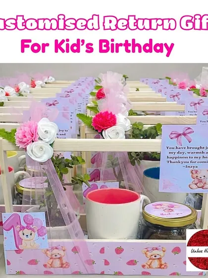 A close-up of the customized return gifts for a kid's birthday, featuring a pink teddy bear theme with personalized cards.