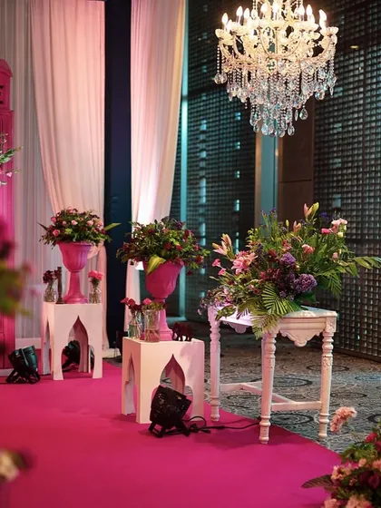 The pink telephone booth and chandeliers create a glamorous and whimsical atmosphere for the event.