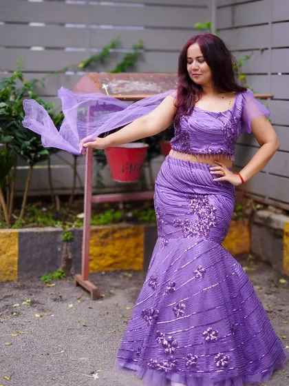This shot shows the beautiful flow of the cape sleeves on the purple sequin gown. It's all in the details.