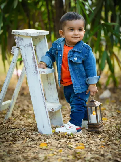 This little guy looks so cool and confident during his outdoor session. The denim jacket and lantern prop add a rustic, adventurous feel.
