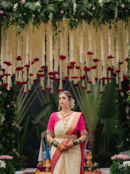 A stunning portrait of a Maharashtrian bride standing before the mandap, looking regal and composed.