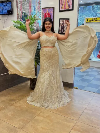 Feel like a star in this shimmering mermaid lehenga with dramatic cape-like sleeves. The fit is designed to flatter your curves, making it a perfect reception outfit.