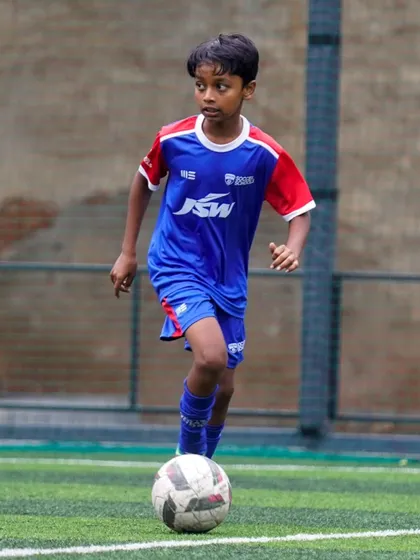 A young player dribbles with his head up, scanning the field. This is a key habit we instill in all our athletes to improve their game awareness.
