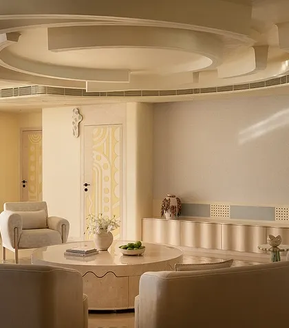 A view of the Soft Serve living area, showing the sculptural ceiling detail that mirrors the circular forms of the furniture and the layout.