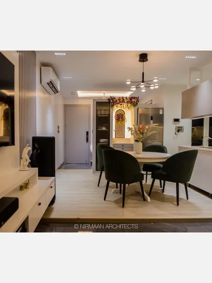An open-plan living and dining area in our Bhagwati Greens project. The island kitchen flows into the dining space, which is defined by a modern chandelier and comfortable seating.