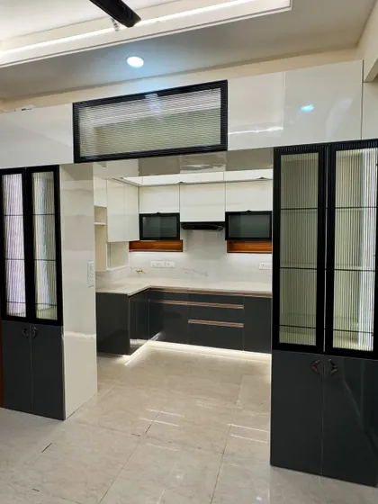 This view shows how the kitchen opens into the dining area, with matching crockery units creating a cohesive and expansive feel. The design is perfect for an open-plan home.