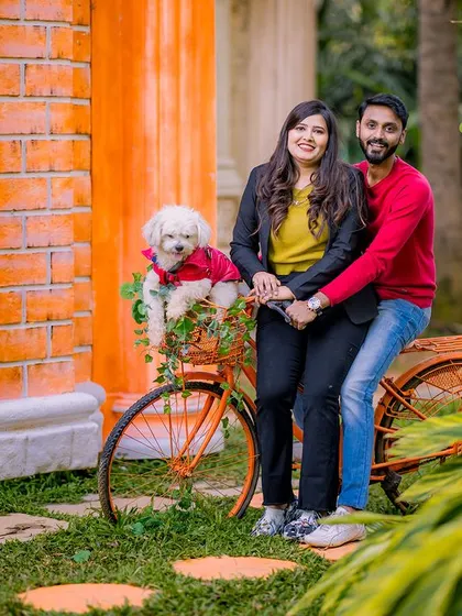 A lovely portrait of a couple with their adorable dog in a bicycle basket. Including pets in your pre-wedding shoot is a great way to make it even more personal.