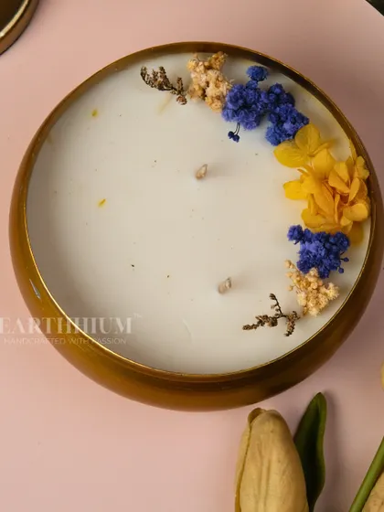 This new luxury Urli candle is adorned with dried blue, yellow, and cream-colored flowers. The natural, earthy tones make it a calming and beautiful addition to any room.
