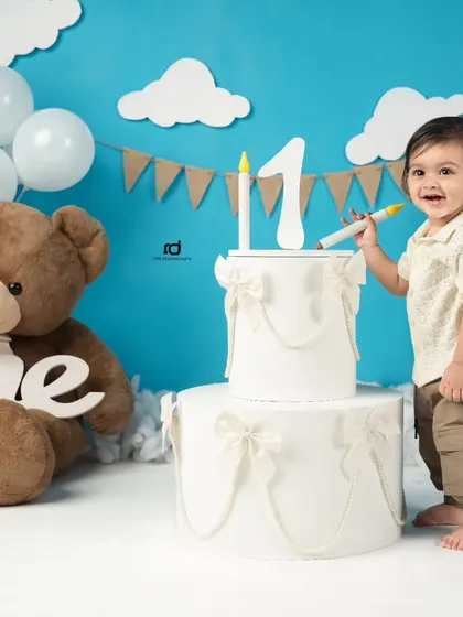 A happy moment by the birthday cake. His smile shows how excited he is to celebrate turning one.