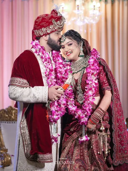 A sweet and candid moment between a North Indian bride and groom, the groom placing a gentle kiss on her forehead.
