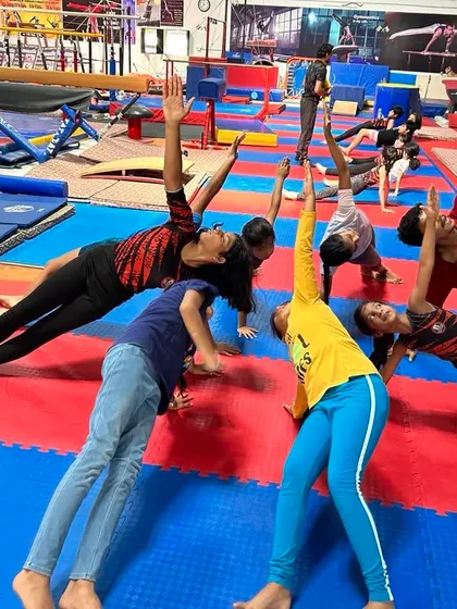 Students engage in a partnered stretching exercise to improve side body length and shoulder mobility. Group stretching adds an element of fun and motivation to our classes.