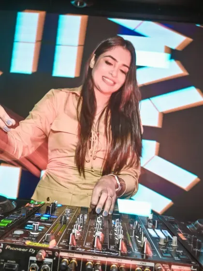 A smiling shot of me at the Pioneer DJ console, with a vibrant LED screen behind me. This shows the professional setup and happy energy I bring to every gig.