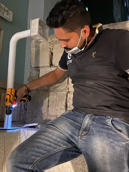 I pay attention to detail, even in tough spots. This is me installing a weatherproof junction box and conduit for an outdoor camera on a stone wall.