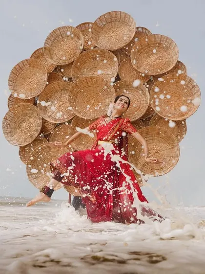 The powerful crash of a wave meets the dynamic pose of the dancer. This image from a creative photoshoot captures a moment of high drama and energy.