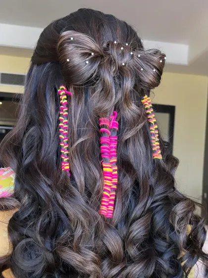 A full back view of this creative Mehendi hairstyle. It features a large bow made of hair, pearl details, and colorful thread braids, combining multiple techniques you'll learn in my class.