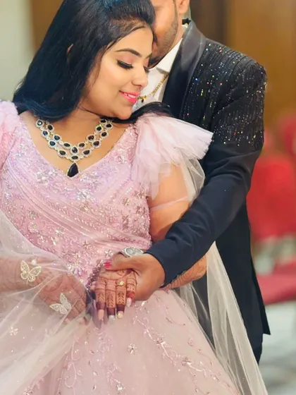 A tender moment during their engagement celebration. The bride's soft pink gown with butterfly details on the sleeves adds a touch of whimsy and romance.