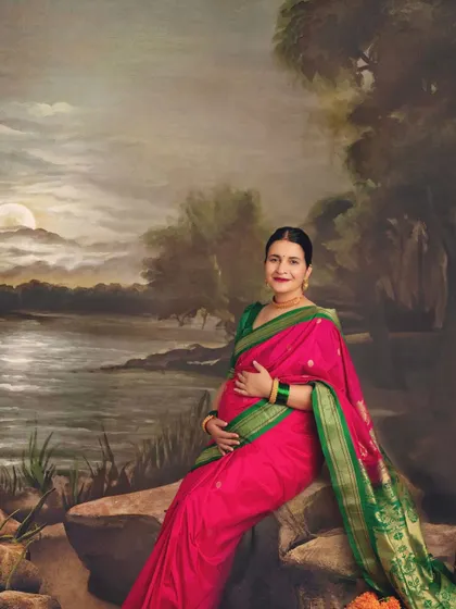 This portrait feels like a timeless painting. The painted backdrop of a moonlit river complements the traditional saree beautifully.