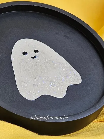 A simple yet spooky ghosty trinket tray. The round black tray has a cute, shimmery ghost in the center, perfect for holding your favorite spooky season jewelry.